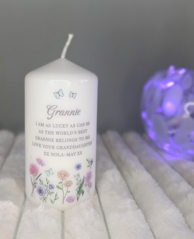 White pillar candle with flower print. Personalised with a name and a message